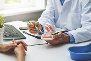 A patient consulting their dentist about dental implant treatment