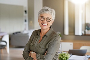 Woman with glasses smiling in living room