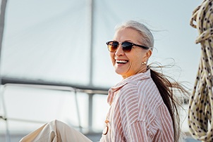 Woman smiling while sitting on boat on lake